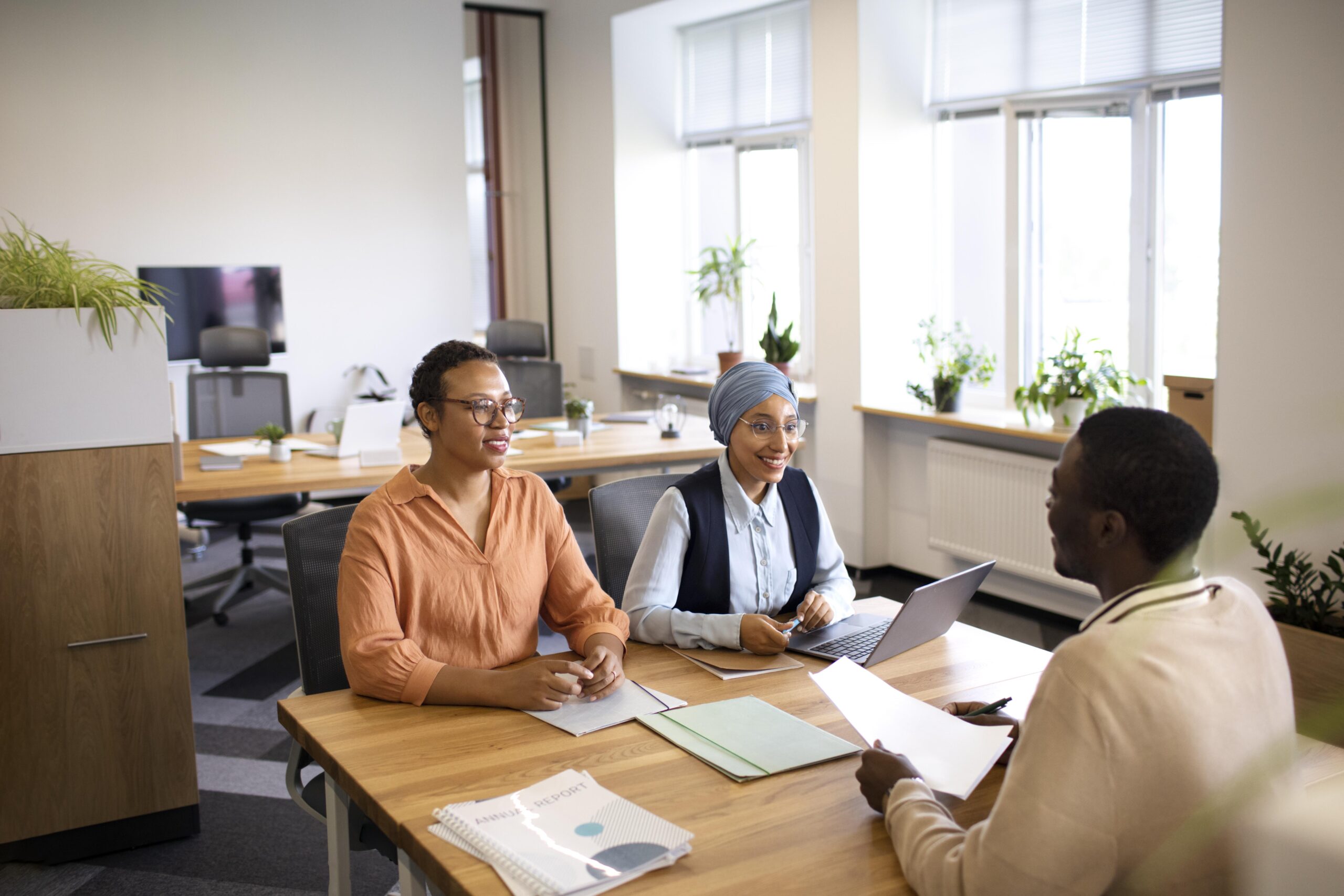 man-sitting-down-office-job-interview-desk-with-his-employers (1)